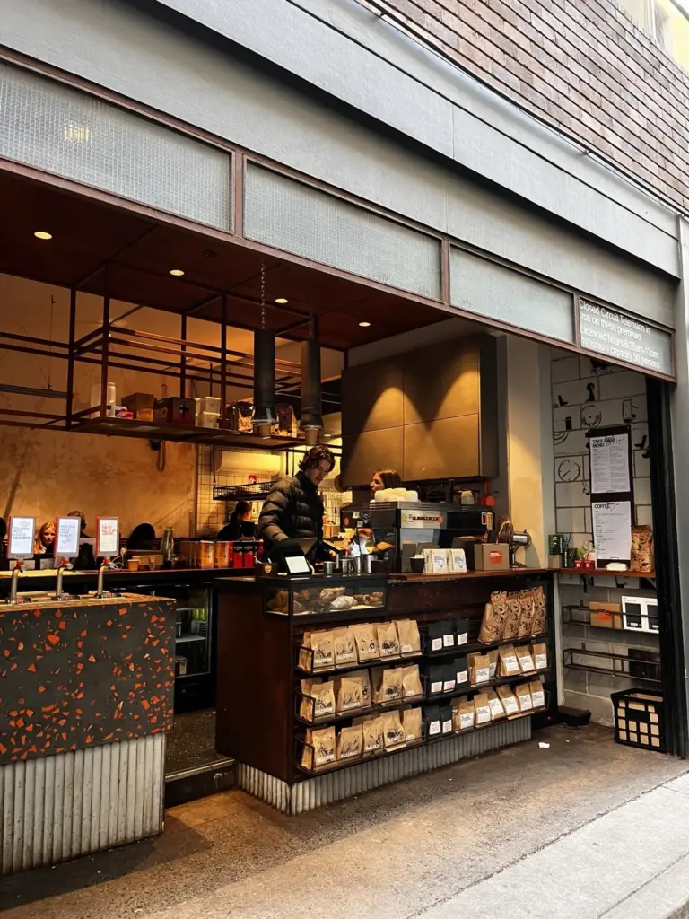 Specialty café storefront with coffee beans displayed outside the entrance.